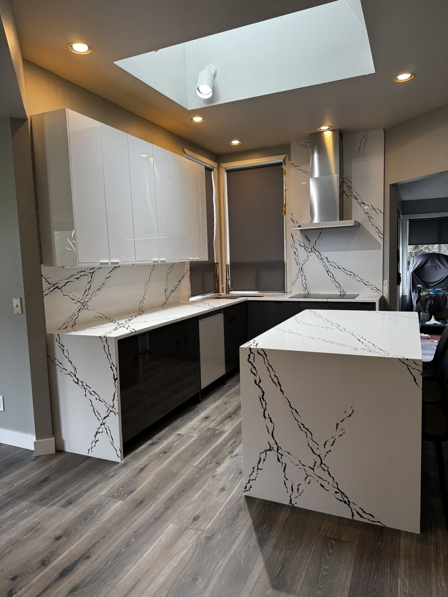 Black and white kitchen with full-height veined stone and a wrapped island