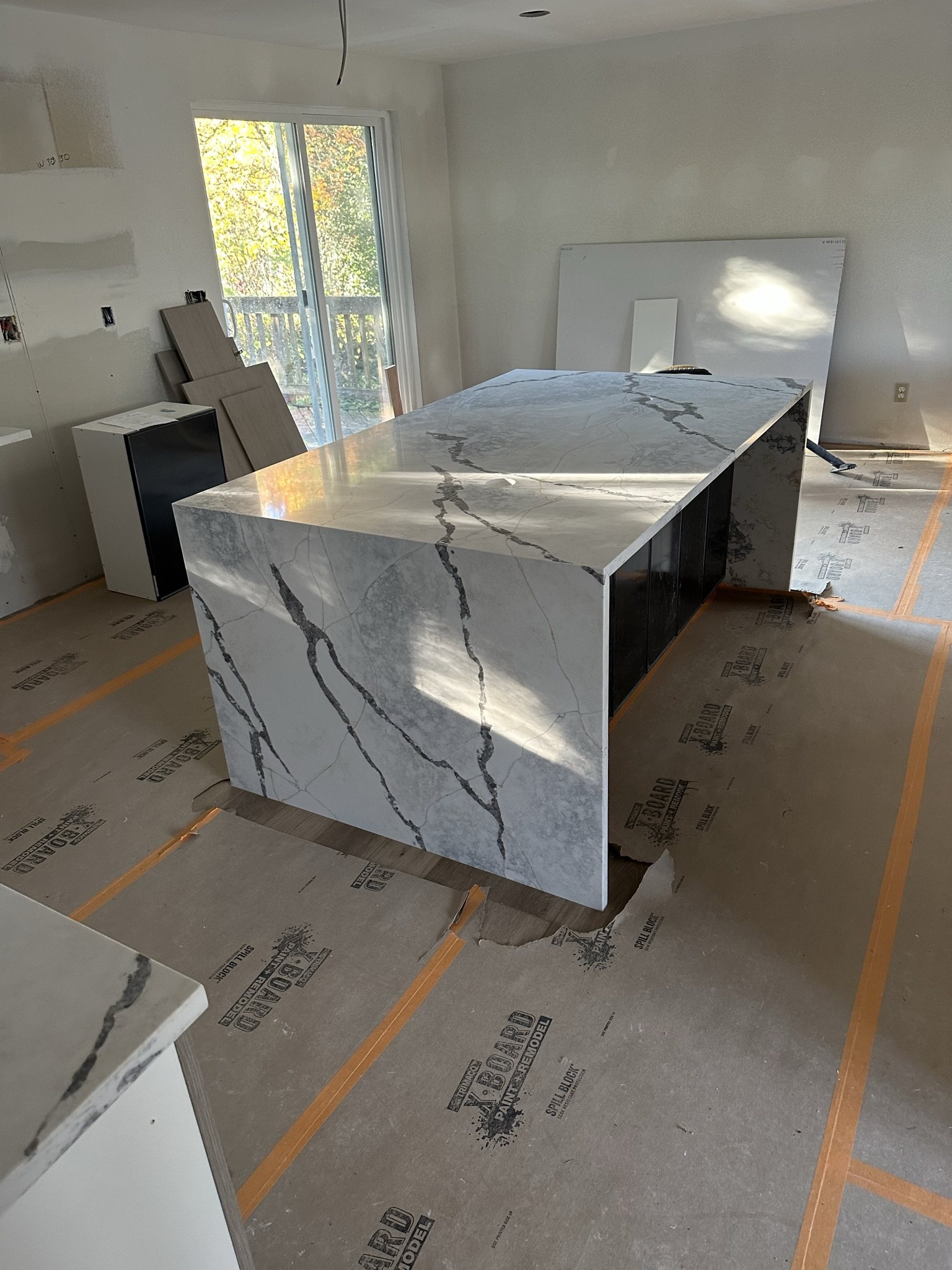 Pale stone island with waterfall edge and dramatic natural veining