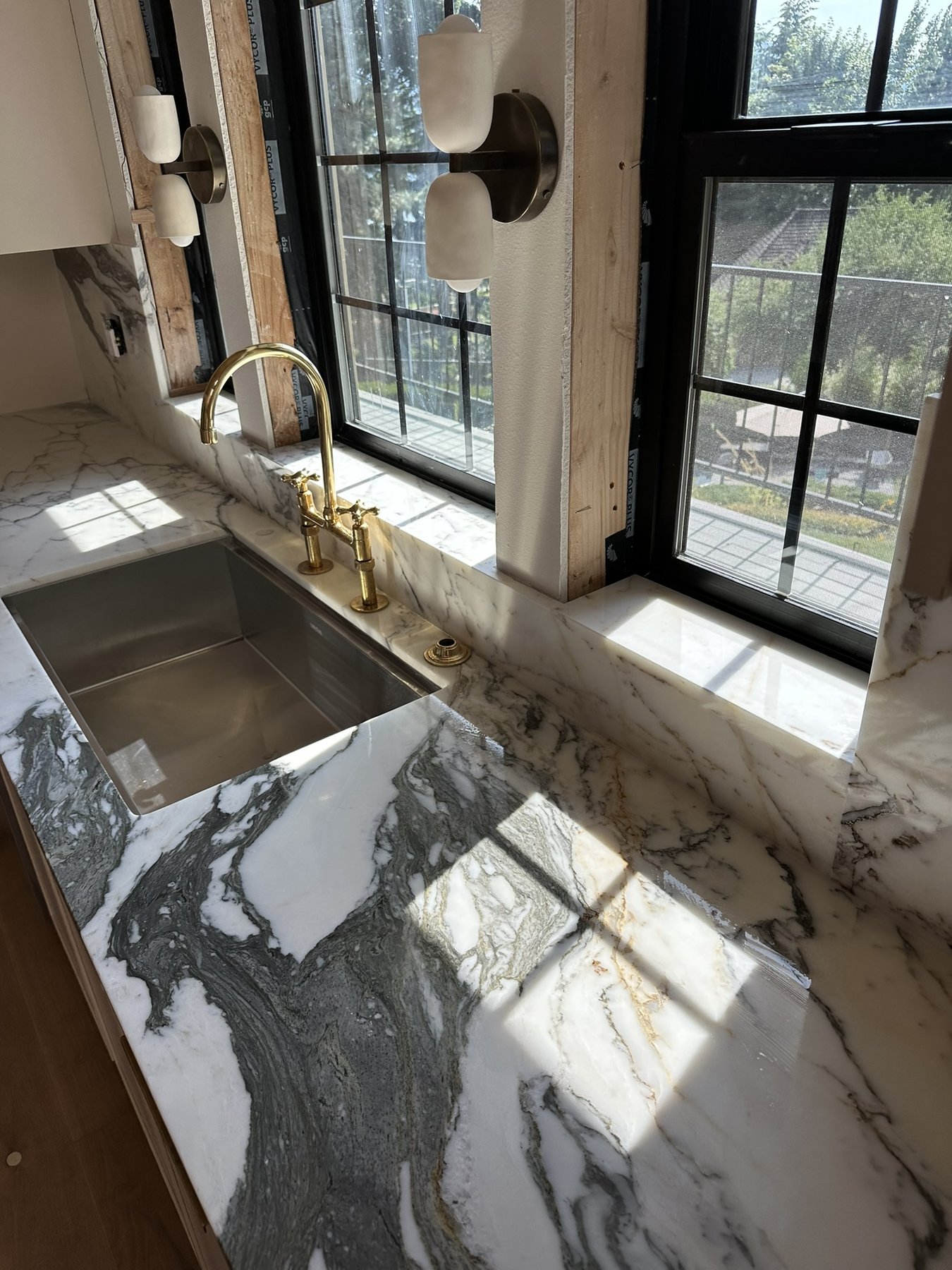 Natural marble countertop, window sills, backsplash, and sink surround with carefully aligned veining