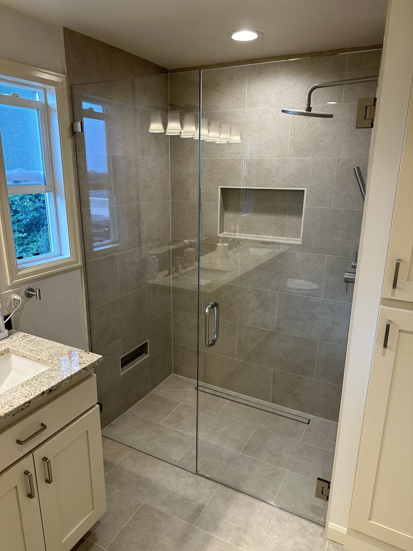 Finished bathroom with full-height pale stone wall panels and a freestanding soaking tub