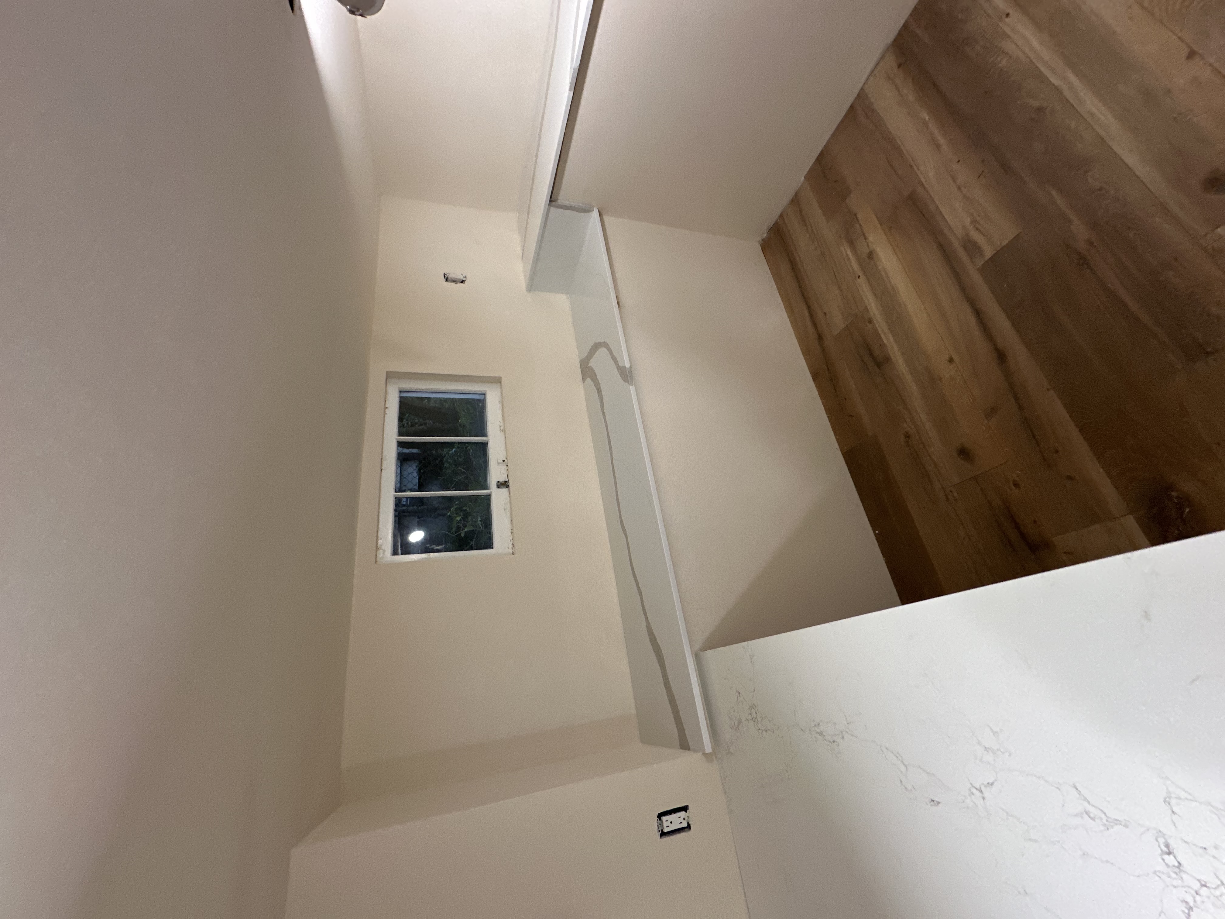 Compact room with wraparound white stone counters and a raised serving ledge